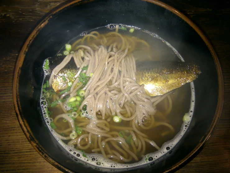 a bowl filled with noodles and broth with vegetables