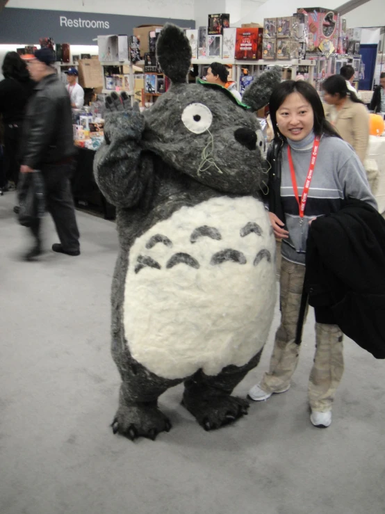 a woman posing next to a stuffed gorilla