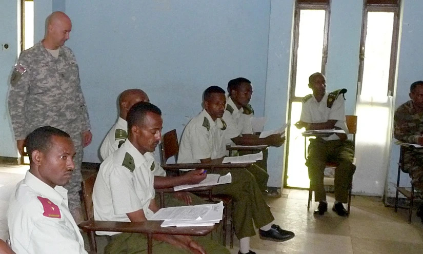 there are military men standing in an indoor classroom