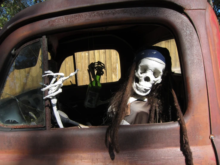 a skeleton in a car is holding a pipe