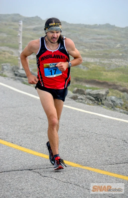 a man running in a trail wearing glasses and running through a rural country