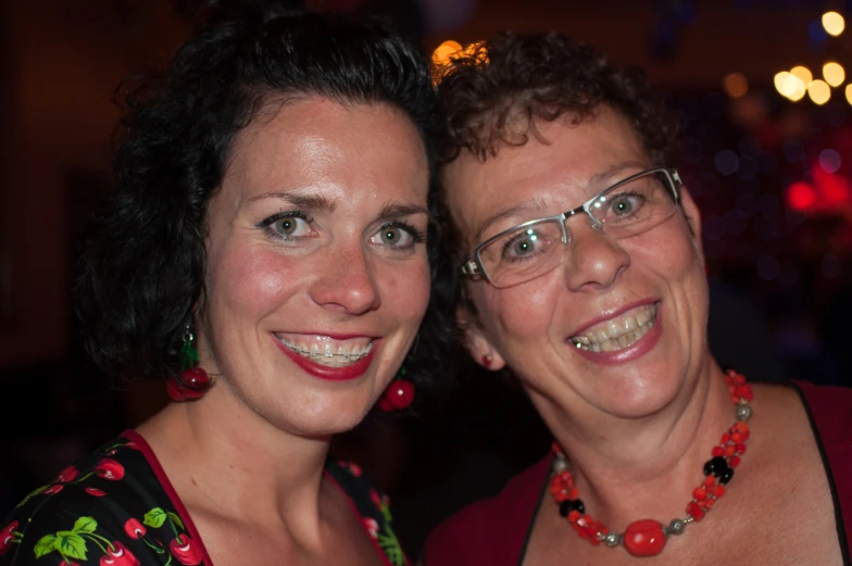 two women in a red shirt are posing for a po