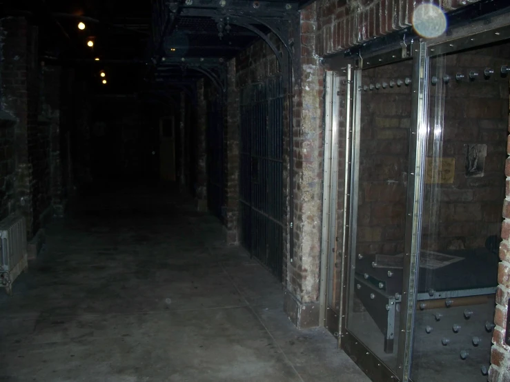 an alley with red brick walls and metal bars