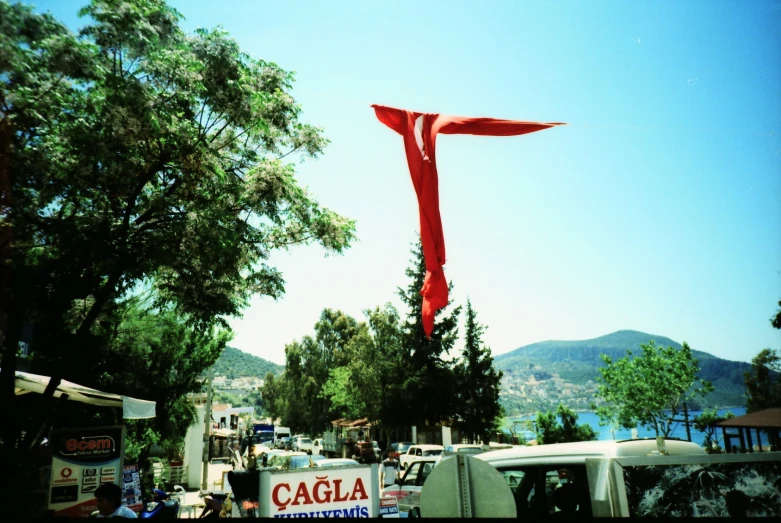 a large red kite on top of a metal pole