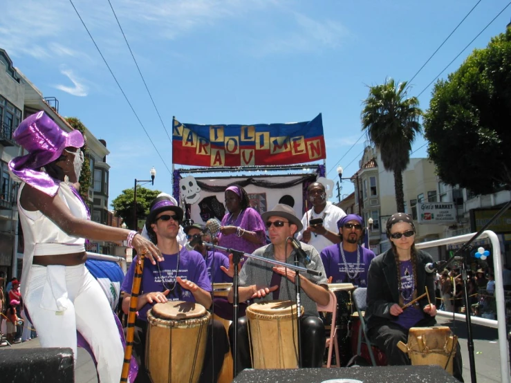 a group of people are standing in the street with drums