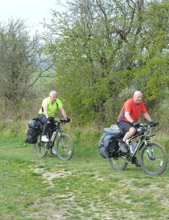 two men are on bikes with the backpacks in the back