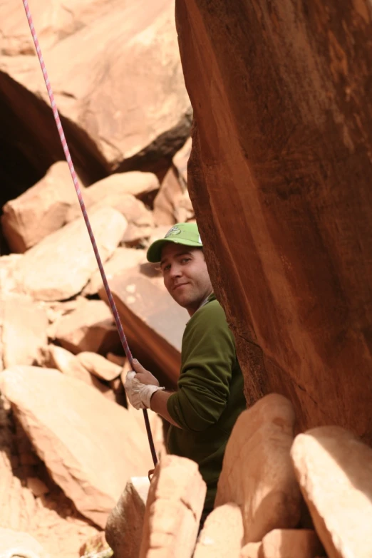 a man climbing on a rock with a rope