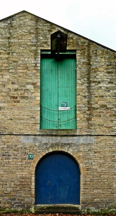 a large door is open to a small brick building