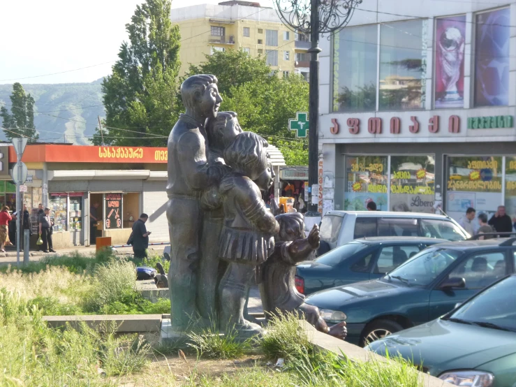 two statues of children with one holding another in their arms