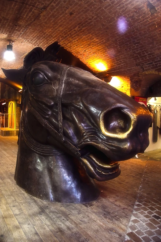 a giant black leather dog head sculpture in a large room