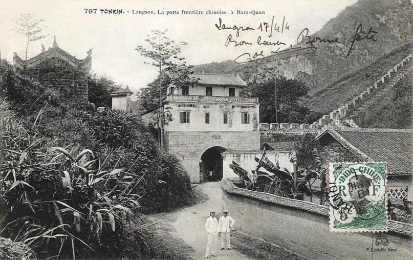 a chinese gate with people walking up it in a town