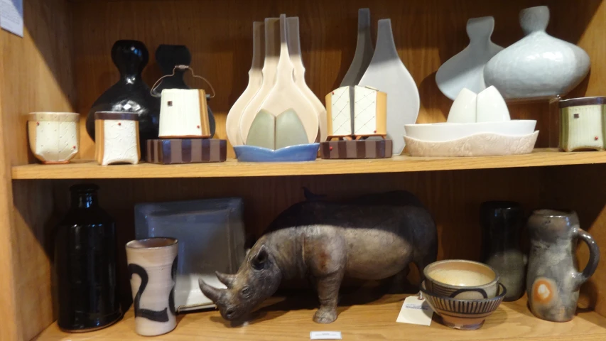 a display of pottery and ceramics on shelves