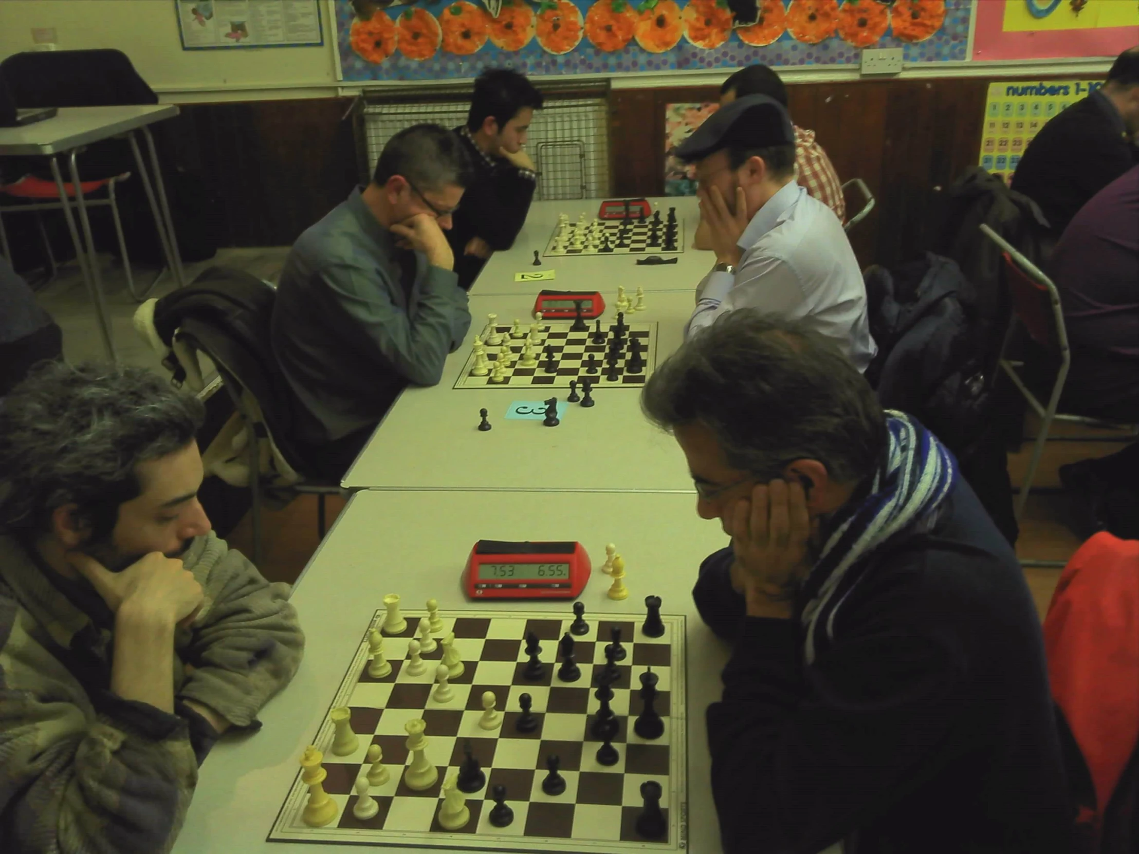 a group of people playing chess and check the board