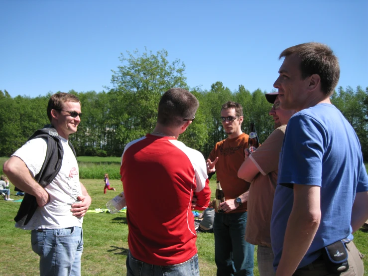 four guys are talking in the middle of the field