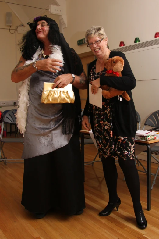 two women in dresses standing next to each other