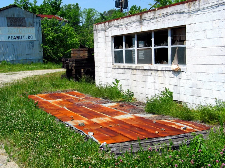 an old wooden floor is left outside by a shed