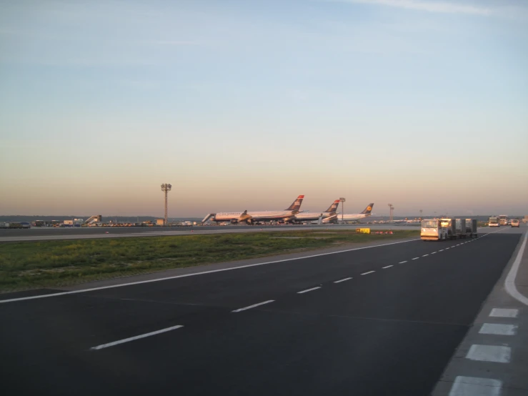 two planes sit on the tarmac near an airport