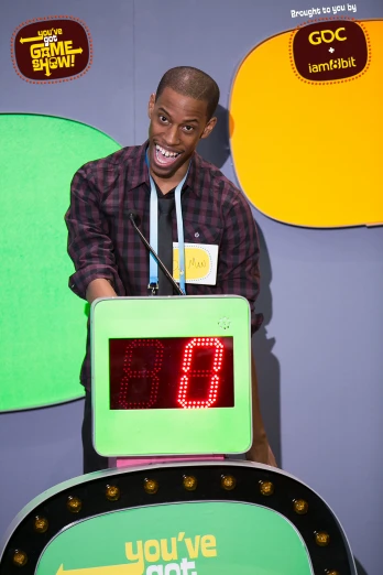 a young man standing behind a small counter top clock