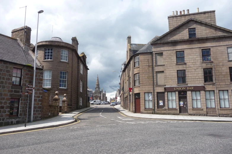 a street with an old - fashioned stone building in the middle