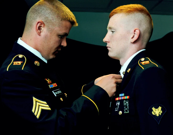 two men in military uniforms standing next to each other