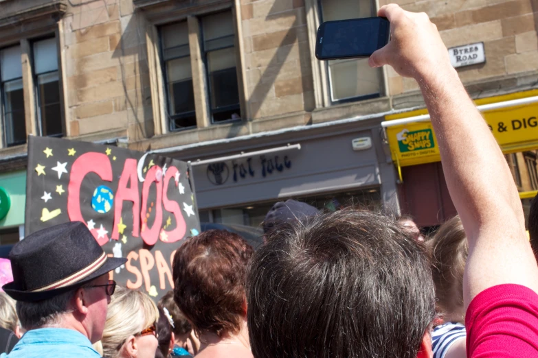 people with cell phones in the foreground and a woman holding a microphone up to their ears