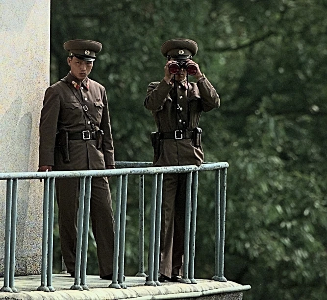 two men in police uniforms standing on the balcony