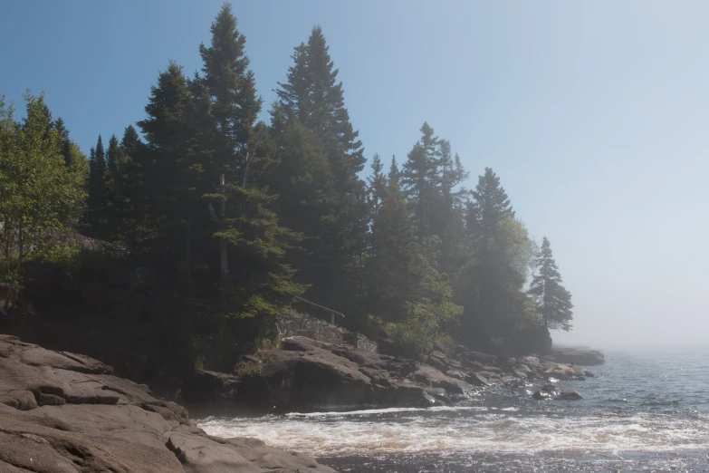 large rocks on shore line on a very foggy day