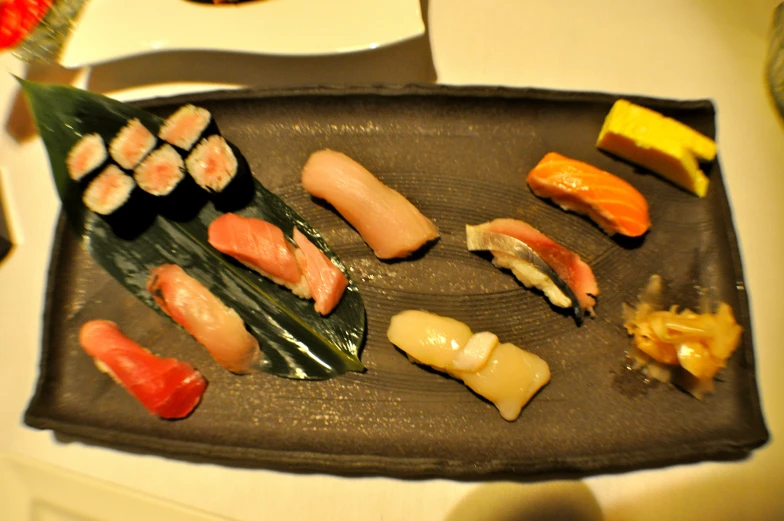 there is sushi and a roll on the square plate