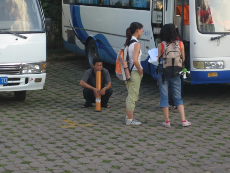 young people standing next to a bus outside