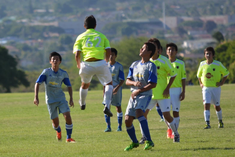 soccer players with one ball in the air