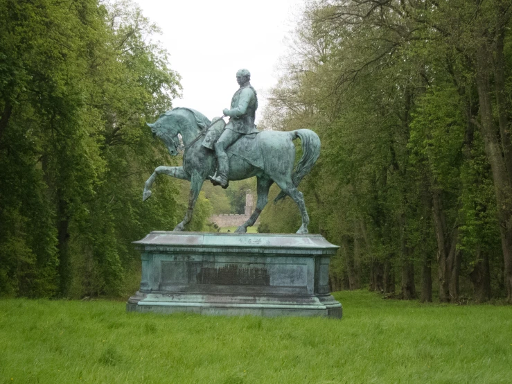 a man on a horse statue is in the middle of the field
