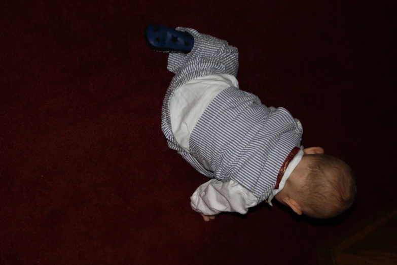 a baby crawling on the floor with his foot on the ground