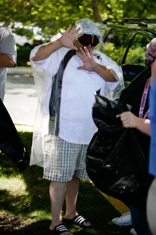 a man holds his hands up with a plastic bag over his face