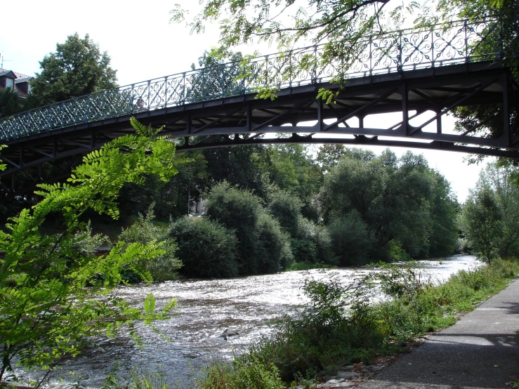 a river under an overpass with trees in the background