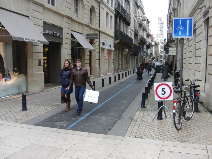 two women walking down the road with a sign for parking on either side of the street