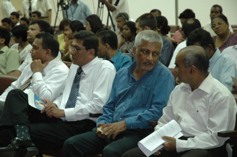 group of people sitting side by side in a lecture hall