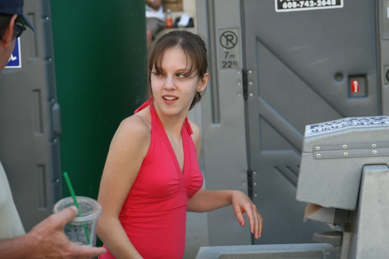 a woman in a red dress is near an atm machine