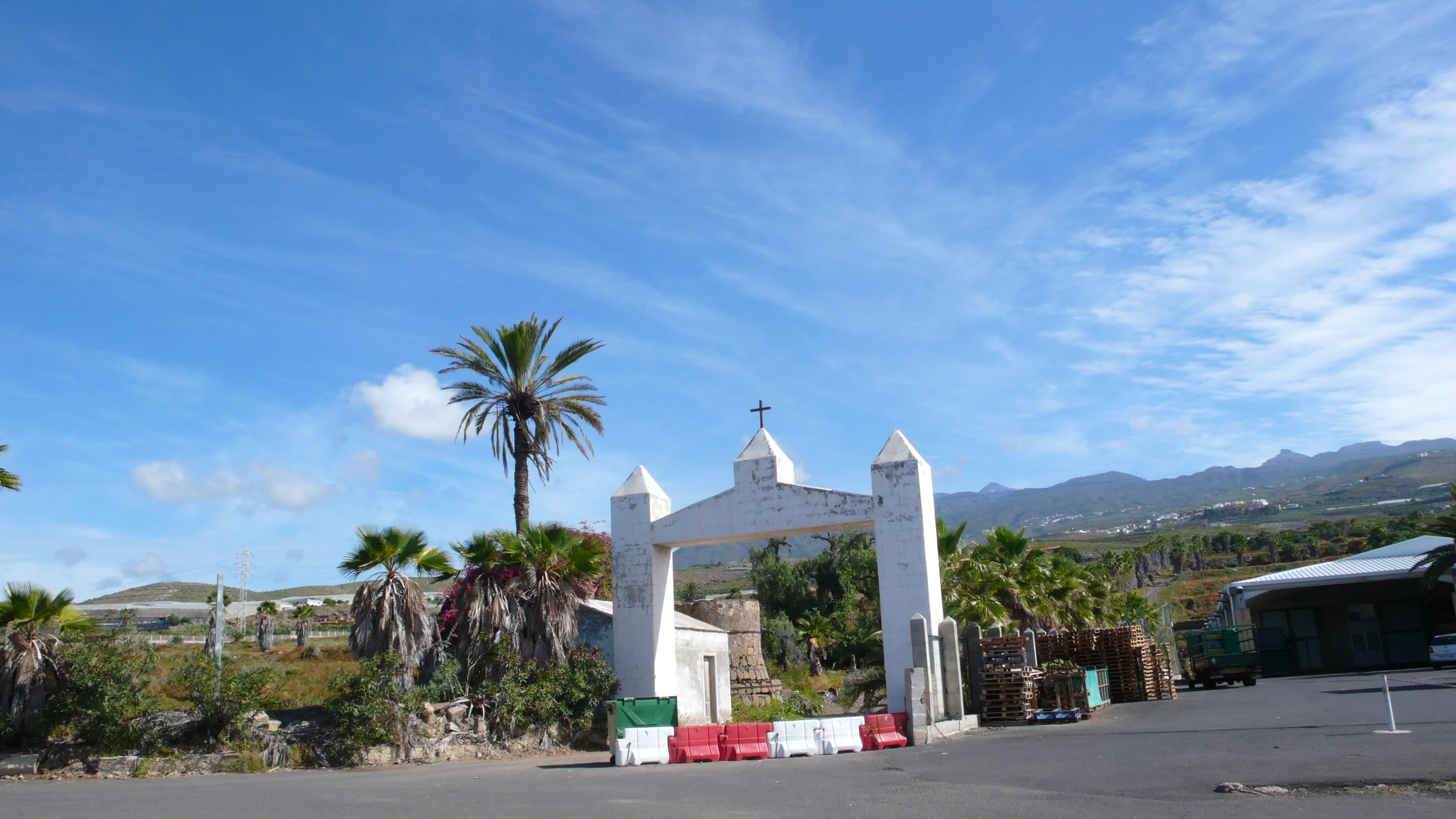 a white arch sitting in the middle of a parking lot