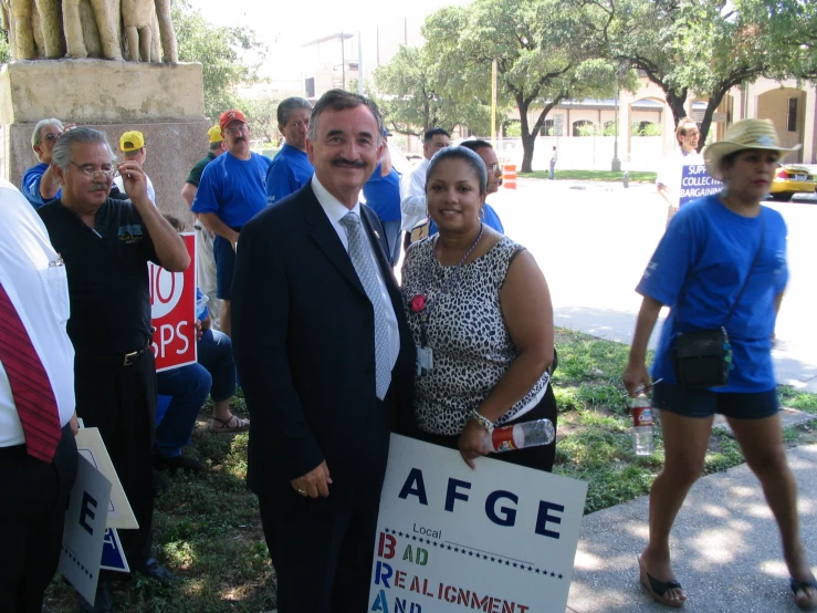 a man and woman are posing together while holding signs