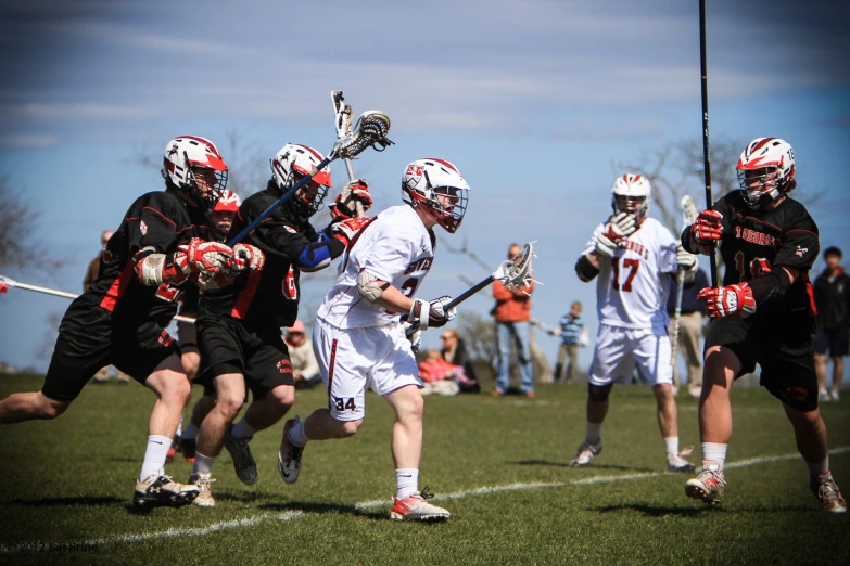 lacrosse players going after each other on the field