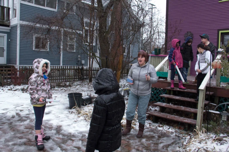 a group of people stand in front of a purple house in the winter