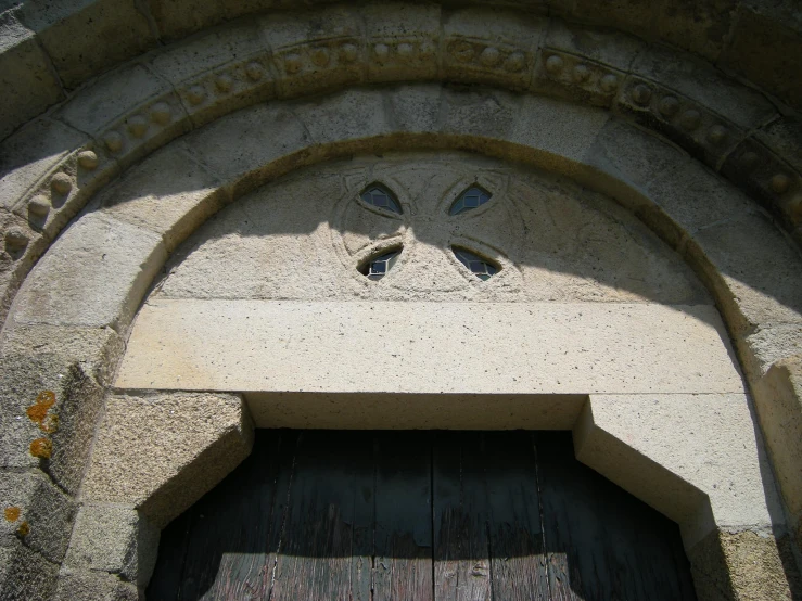 an old building with large arched windows, a stone facade and wooden doors