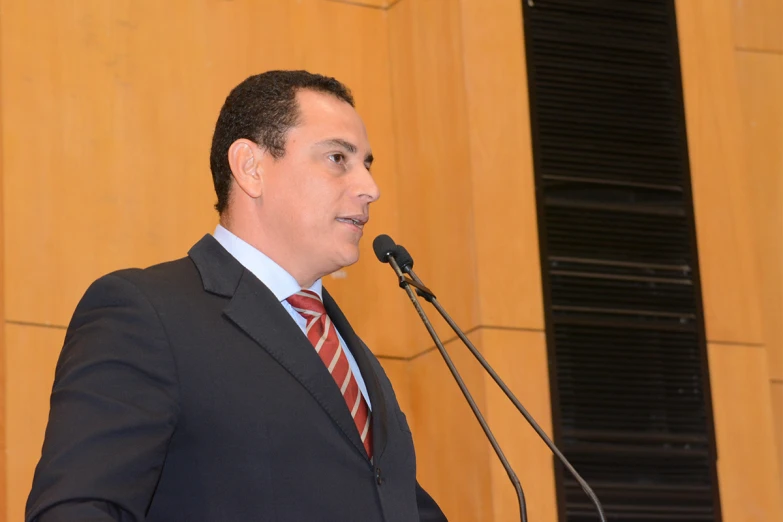 man giving speech in front of speaker in a conference