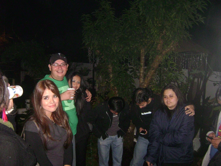 a group of people standing together outside at night