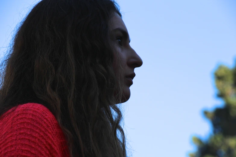 a close up of a person's face with a sky in the background