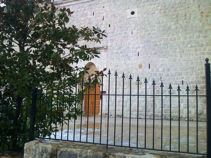 a building that is outside with iron fencing and trees