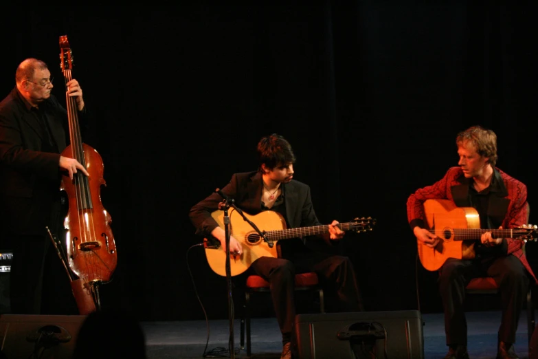 a couple of guys with guitars and one is playing the guitar