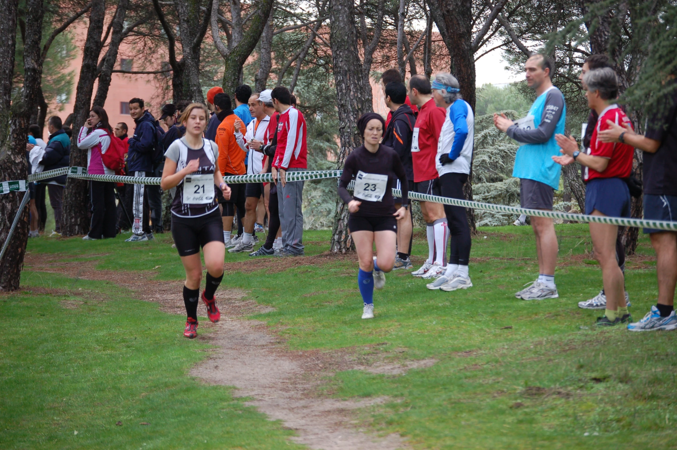 a man is running during the race, with a group of people watching