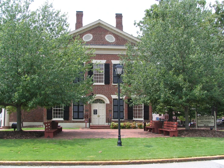 a large house that has trees in the front of it