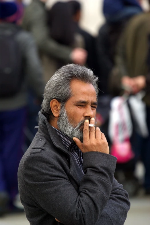 an old man smoking a cigarette and looking ahead